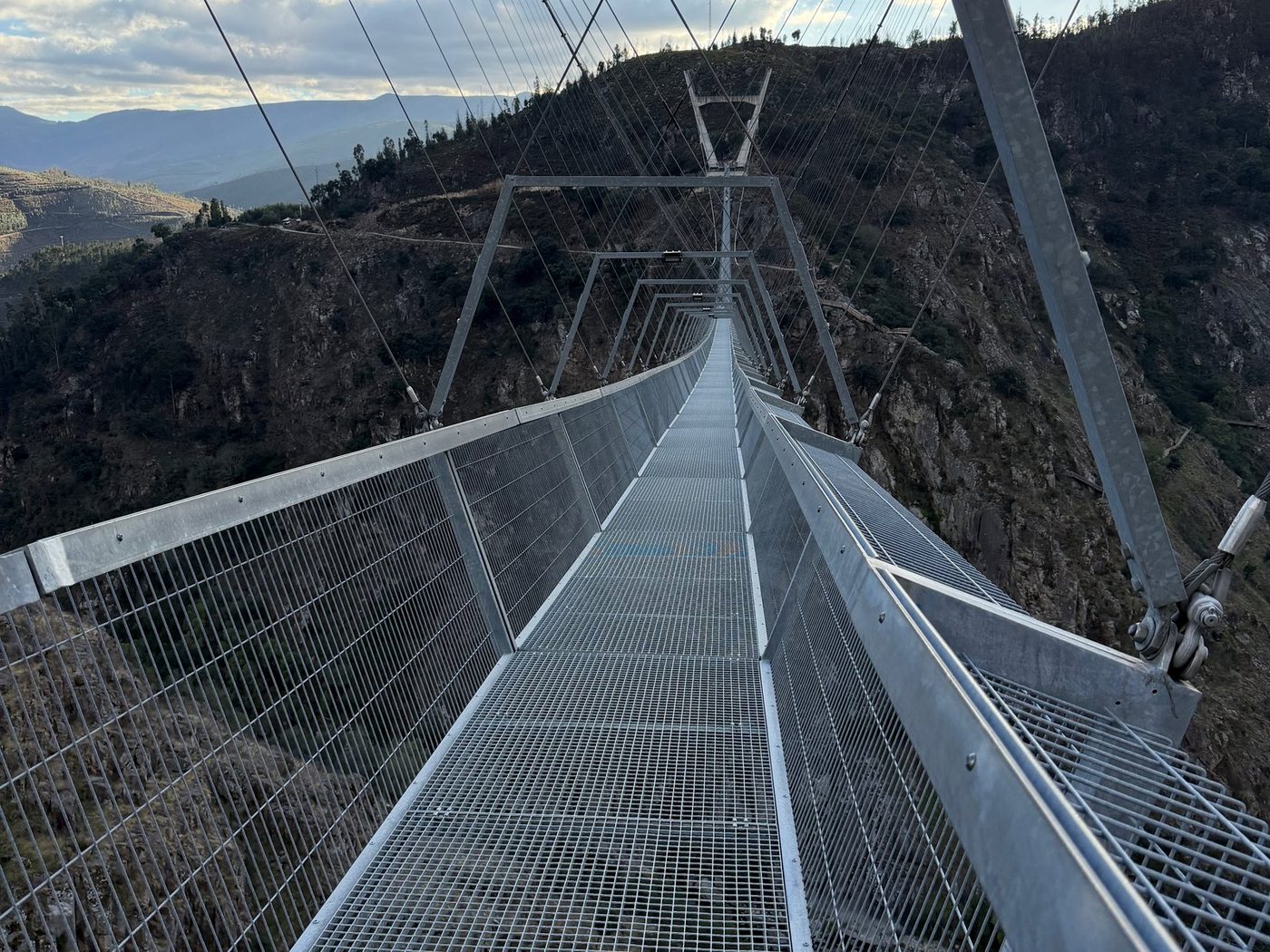 On the deck of the 516 Arouca bridge, a steel mesh walkway hung over the Paiva gorge