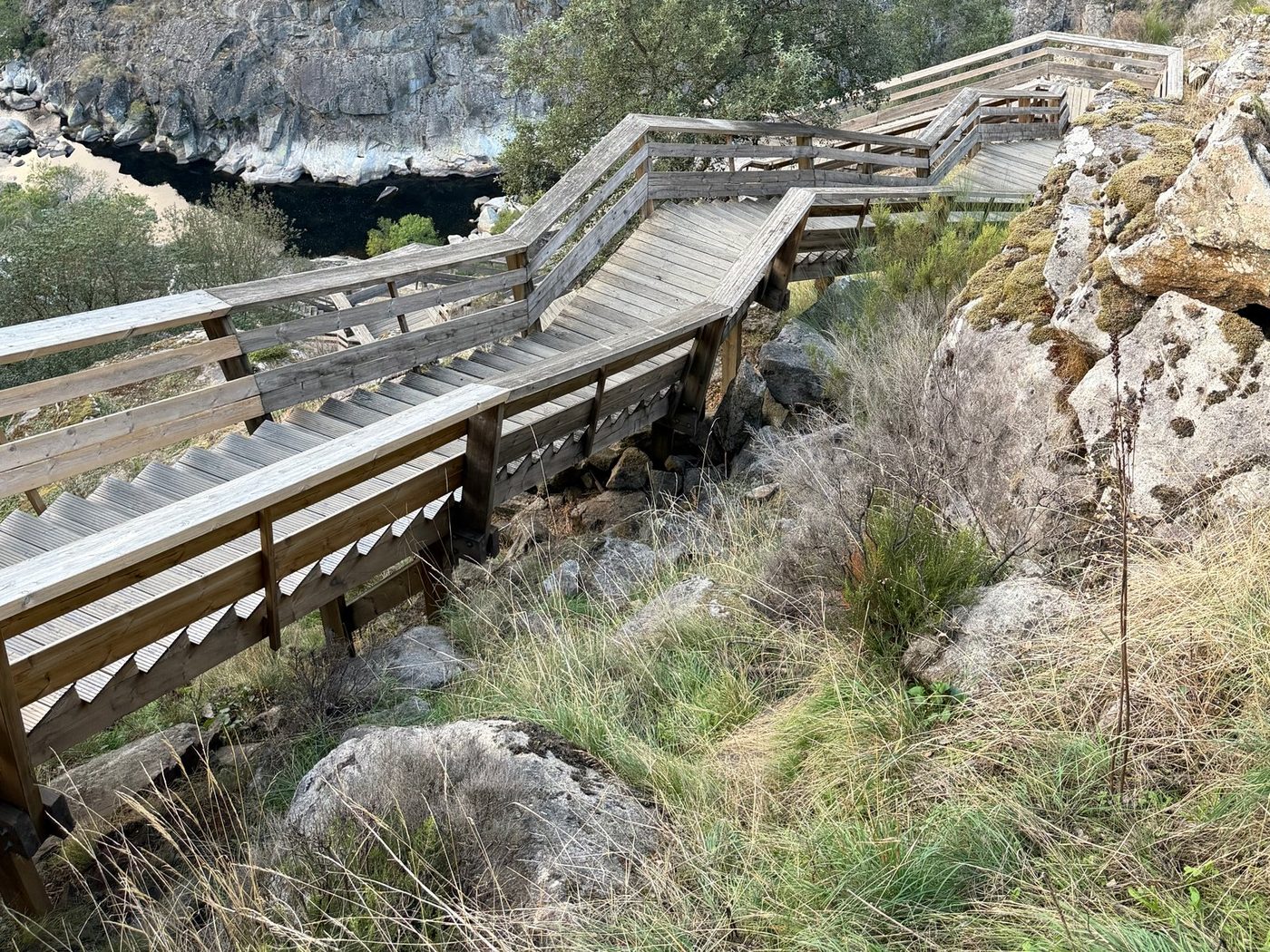 The wooden boardwalk of the Passadiços do Paiva climbing over the rocks above the river