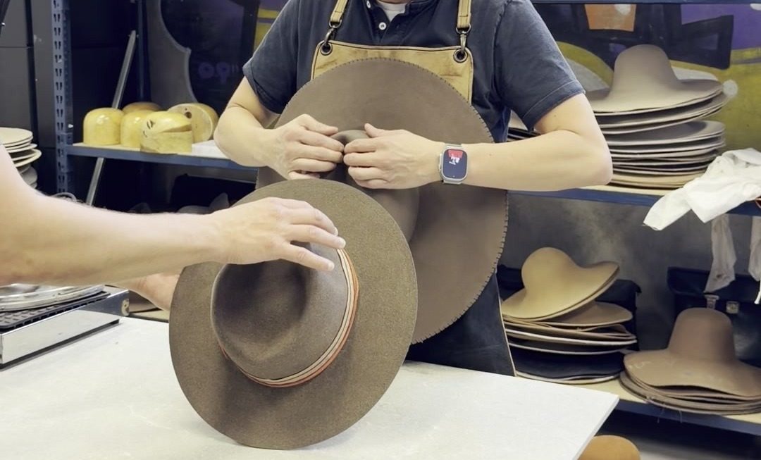 Fitting the band on a handmade hat at Maraus