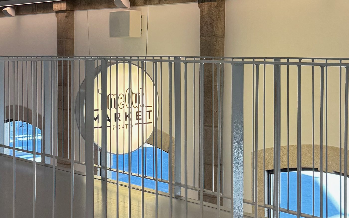 The Time Out Market Porto logo seen through the mezzanine railing, opening week, 8 May 2024