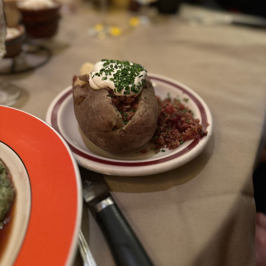 Loaded baked potato with sour cream, bacon and chives at House of Prime Rib, 2022